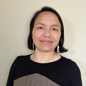 Headshot of Nubia Lopez in front of a beige background.