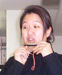 [The assistant teacher demonstrates the pan flute.]