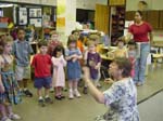 [Head teacher leads the group in song during the open house.]